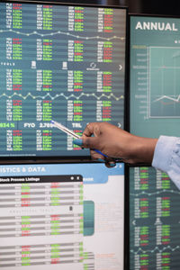 Cropped hands of businesswoman pointing at graph on computer