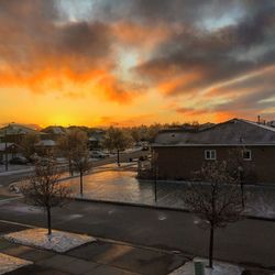 Houses and buildings against sky during sunset