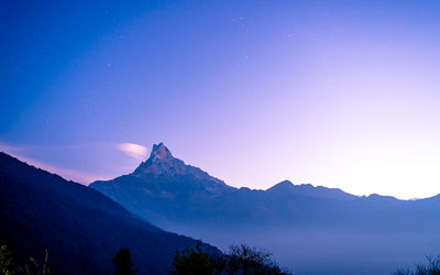 Scenic view of mountains against clear blue sky at night