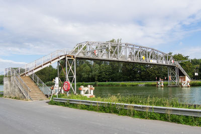 Bridge over river against sky in city