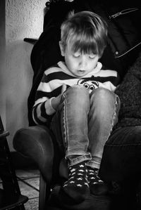 Boy sitting on seat at home
