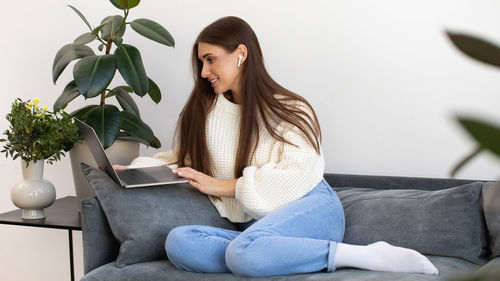 Young woman sitting on sofa at home