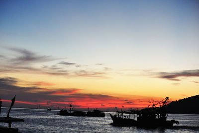 Silhouette boat sailing on sea against sky during sunset