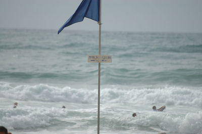 Scenic view of sign on sea against sky