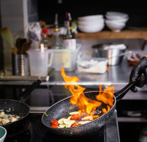 Cropped hand of chef cooking food in kitchen