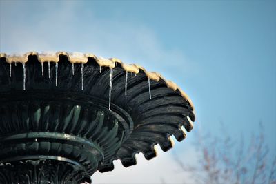 Low angle view of wooden post against sky