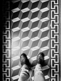 Low section of person standing on tiled floor