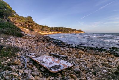 Scenic view of rocks on beach against sky