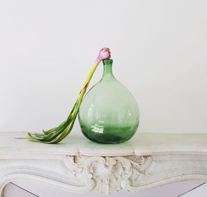 Close-up of glass bottle on table against white background