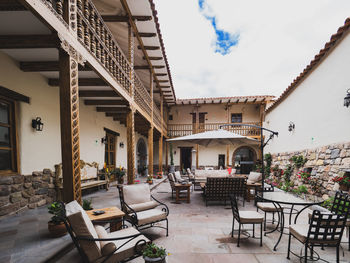 Empty chairs and tables against buildings in city