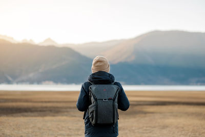 Rear view of man looking at camera