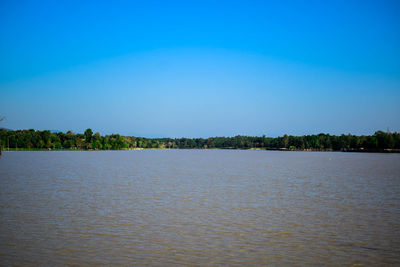 Scenic view of lake against clear blue sky