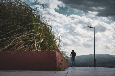 Man standing by tree against sky