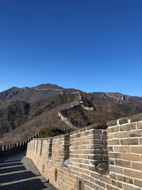 Steps leading towards mountains against clear blue sky