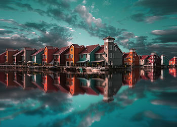 Reflection of buildings in sea against sky