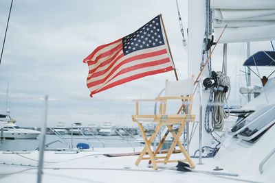 Flag on snow covered landscape against sky