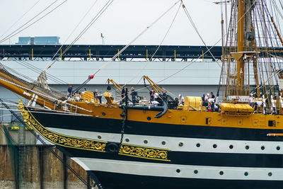 Boats moored at harbor against sky