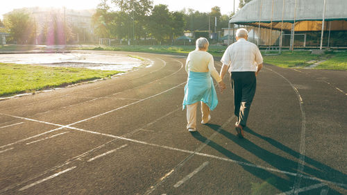 Rear view of men walking on footpath