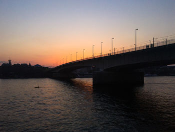 Bridge over river against sky during sunset