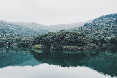 Reflection of trees in lake against clear sky