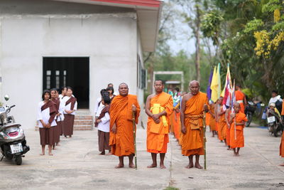 People standing on street by building in city