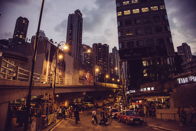 Illuminated street amidst buildings in city at night