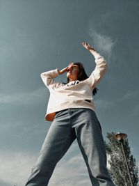 Low angle view of woman standing against sky