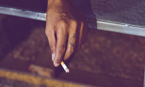 Close-up of hand holding cigarette