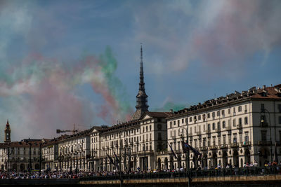 Buildings in city against cloudy sky