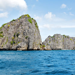 Rock formations by sea against sky