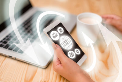 High angle view of man using smart phone on table