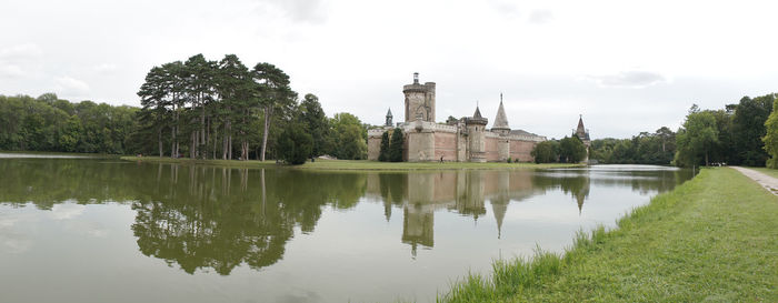 Scenic view of lake by buildings against sky