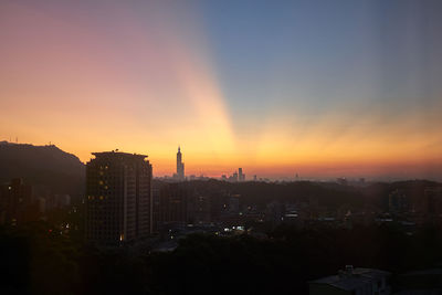 Buildings in city during sunset