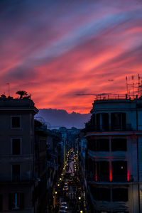 Illuminated buildings against sky at sunset