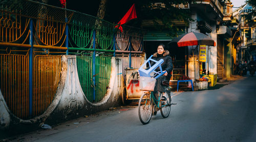 Woman riding bicycle on street at night