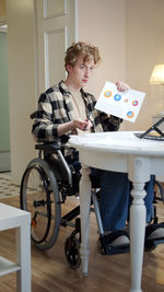 Young disabled man talking on video conference