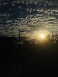 Silhouette electricity pylon against sky during sunset