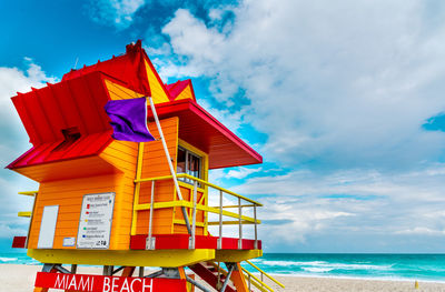 Multi colored umbrellas on beach against sky