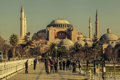 Group of people outside muslim temple against buildings in istanbul