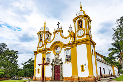 Low angle view of old and historic church with bell and clock tower against sky on tiradentes city
