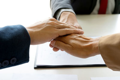 Midsection of man with hands on table