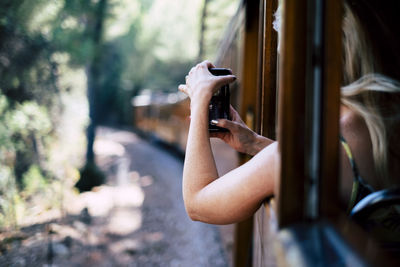 Midsection of woman photographing through smart phone