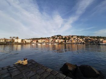 Scenic view of river by buildings against sky