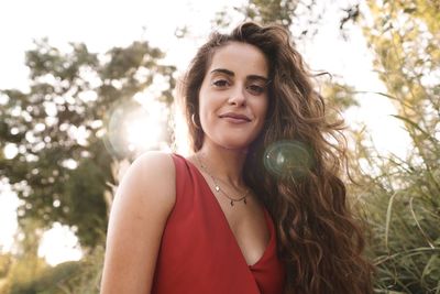 Portrait of smiling young woman against plants