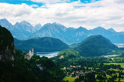 Scenic view of townscape by mountains against sky