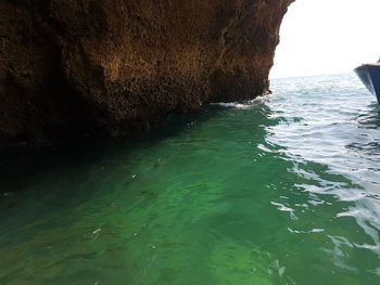 Rock formation in sea against sky