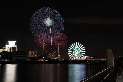 Firework display over river at night