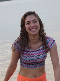 Portrait of happy young woman standing at lakeshore