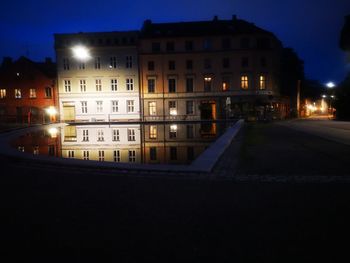 Illuminated buildings against sky at night