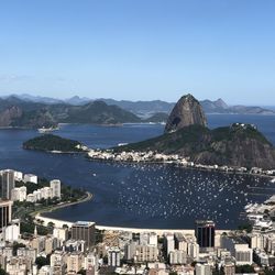 High angle view of city by sea against clear sky